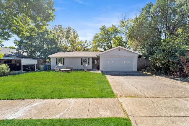 a front view of a house with a garden and yard