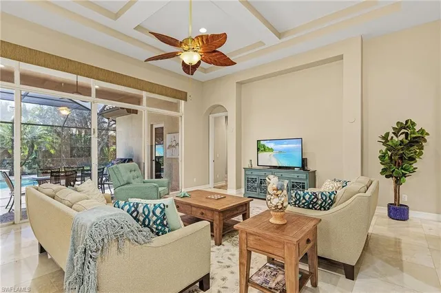 a living room with furniture a chandelier and a flat screen tv