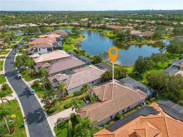 an aerial view of ocean and residential houses with outdoor space