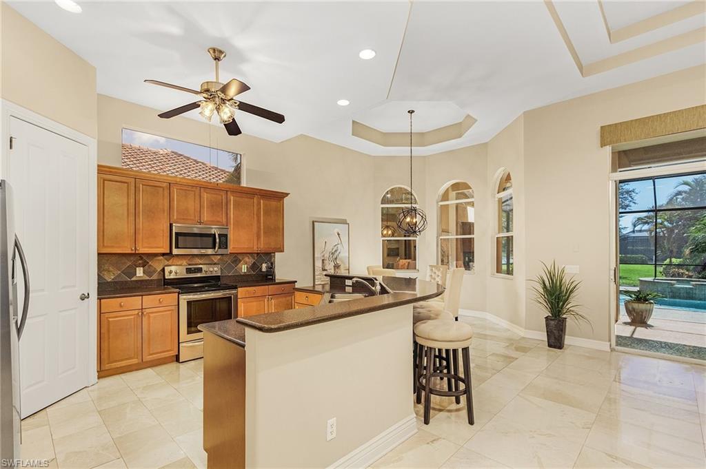 20002 Grande Lake Drive Estero, FL 33928 - Photo 9 of 38 a kitchen with stainless steel appliances a table and chairs in it