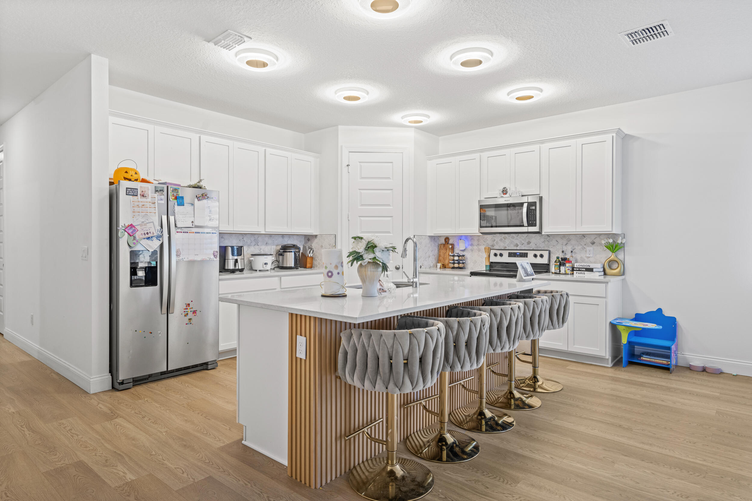 8906 Dahlia Circle Port St. Lucie, FL 34986 - Photo 11 of 47 a kitchen with stainless steel appliances a white stove top oven a refrigerator and a center island