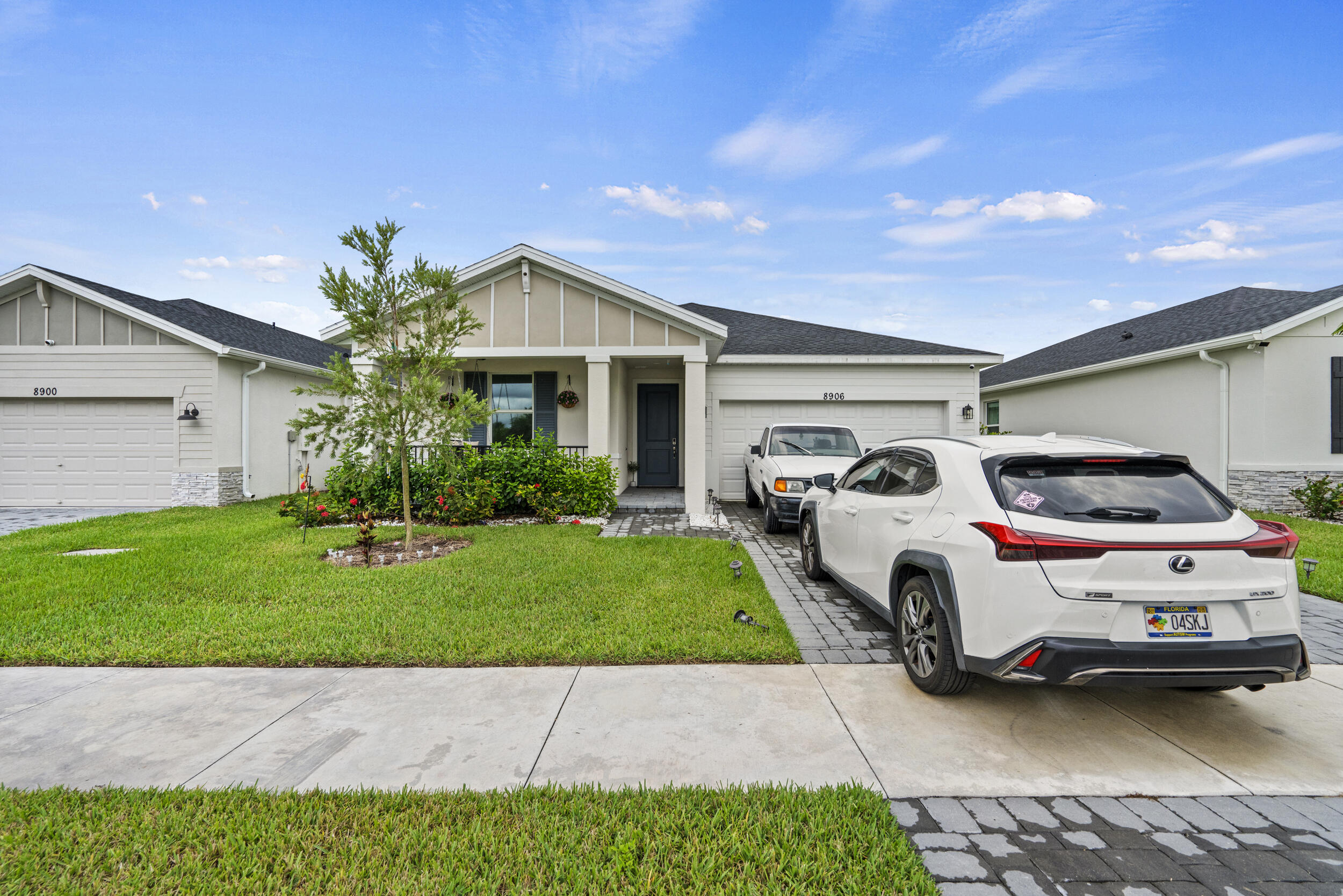 8906 Dahlia Circle Port St. Lucie, FL 34986 - Photo 2 of 47 a front view of a house with a garden