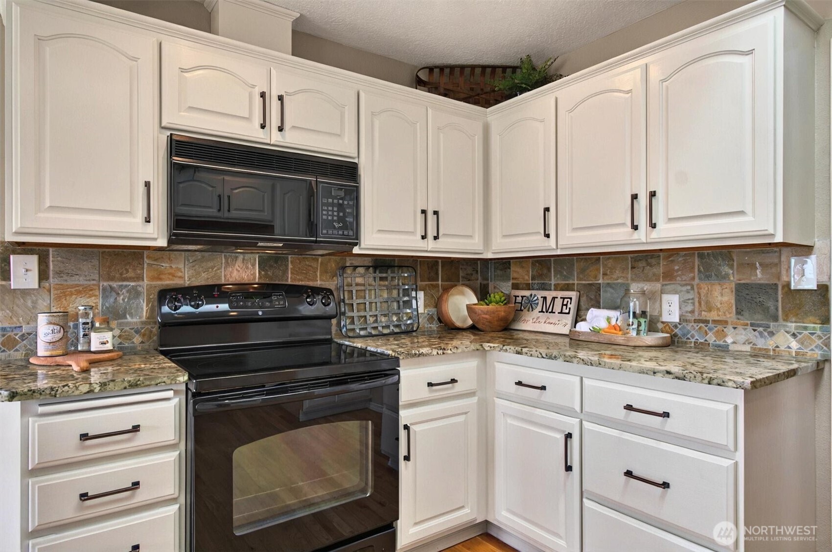 293 Highway 409 Cathlamet, WA 98612 - Photo 11 of 39 a kitchen with granite countertop white cabinets and stainless steel appliances