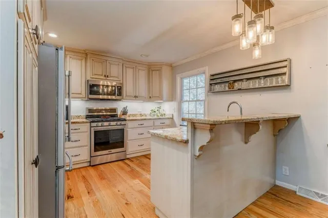 a kitchen with stainless steel appliances granite countertop a stove a sink and a microwave