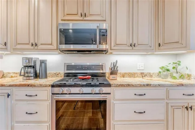 a view of a kitchen with stainless steel appliances granite countertop a sink and cabinets