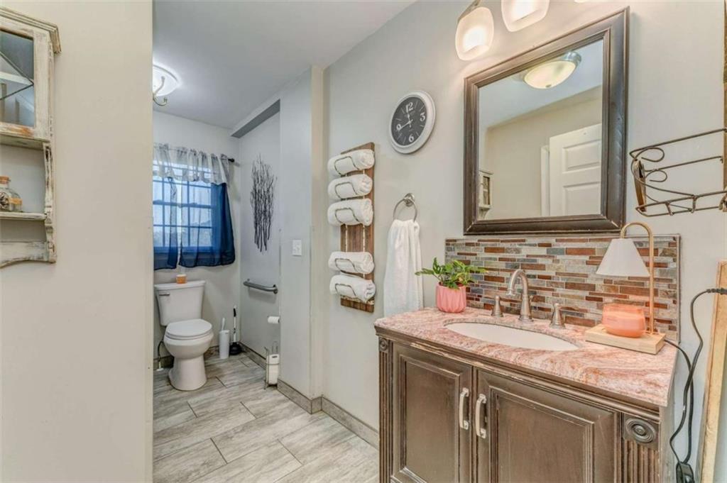 1522 Collard Valley Road Cedartown, GA 30125 - Photo 37 of 56 a bathroom with a granite countertop toilet sink and mirror