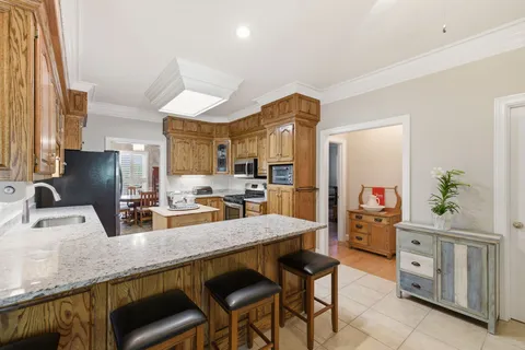 a kitchen with granite countertop a sink cabinets and refrigerator