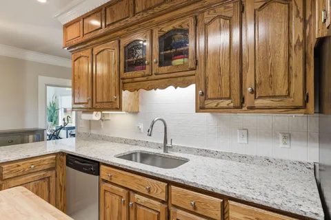 a kitchen with granite countertop stainless steel appliances a sink and cabinets
