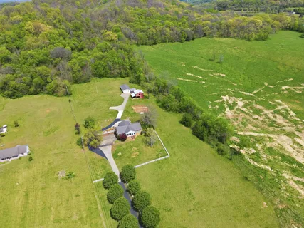 an aerial view of residential houses with outdoor space and trees