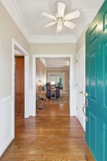 a view of a livingroom with furniture a chandelier and wooden floor