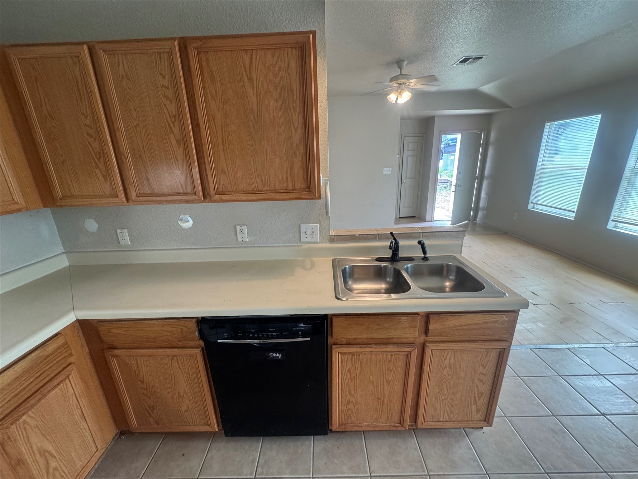 4411 Terra Summit Road San Antonio, TX 78233 - Photo 6 of 11 Kitchen area featuring warm wood cabinetry, a double basin stainless steel sink with a matte black faucet, and a built-in black dishwasher
