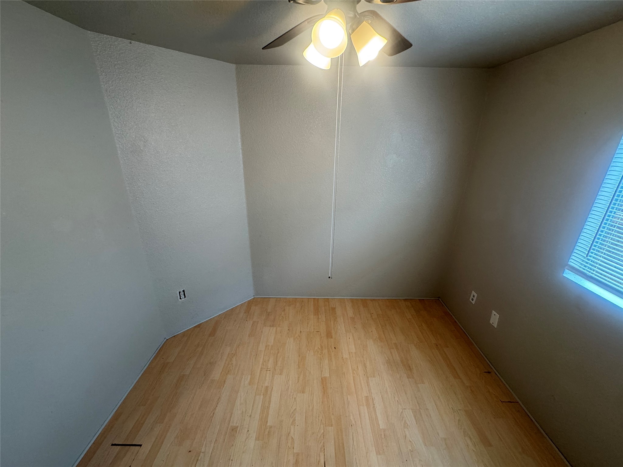 4411 Terra Summit Road San Antonio, TX 78233 - Photo 7 of 11 Room featuring wood-finish flooring, a ceiling fan with integrated lighting, and a window with horizontal blinds