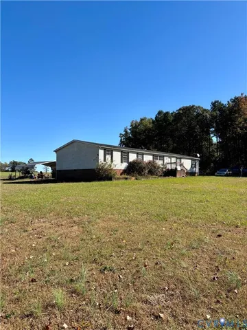 a view of a big house with a big yard and large trees