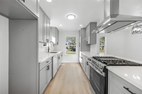 a kitchen with stainless steel appliances a sink stove and cabinets