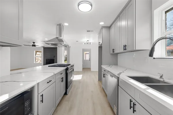 a kitchen with granite countertop a sink stove and cabinets