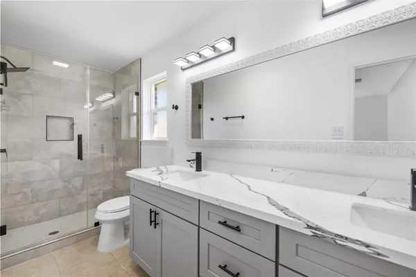 a bathroom with a sink a toilet and shower