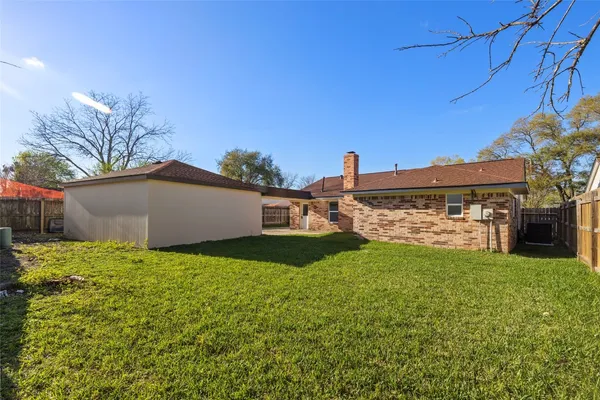 a view of a big house with a big yard and large trees