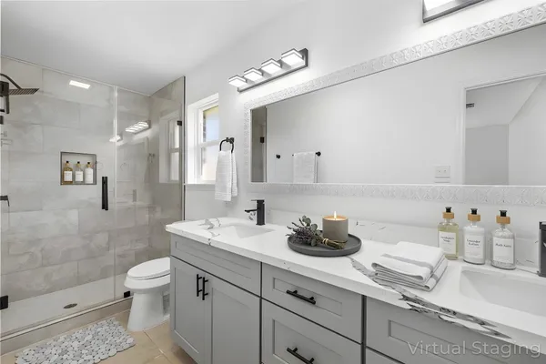 a bathroom with a double vanity sink toilet and shower