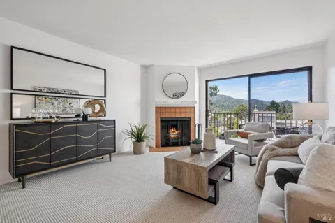 a living room with furniture a large window and a fireplace