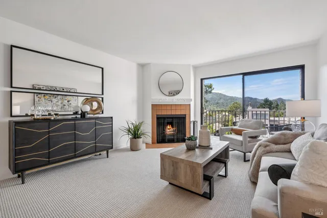 a living room with furniture a large window and a fireplace
