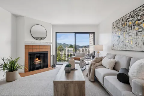 a living room with furniture a fireplace and a large window