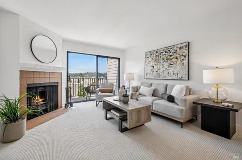 a living room with furniture a large window and a fireplace