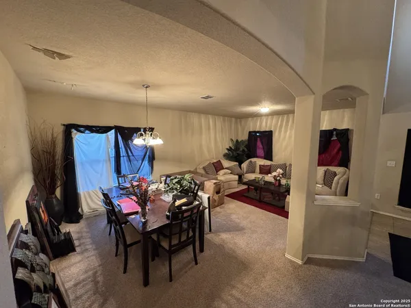 a living room with furniture and a chandelier
