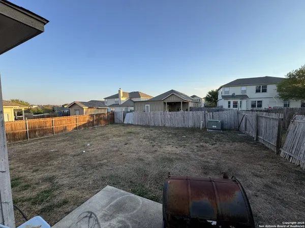 a view of a backyard with wooden fence