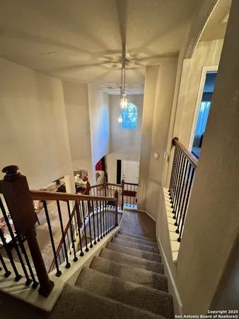 a view of a hallway with wooden floor and stairs