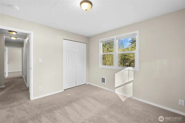 an empty room with windows and closet