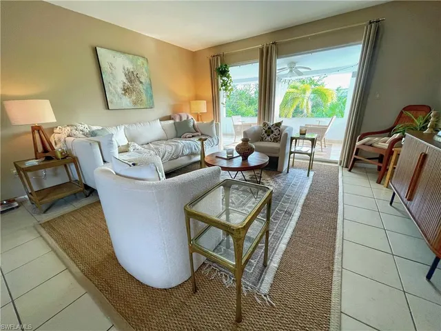 a living room with furniture and a floor to ceiling window