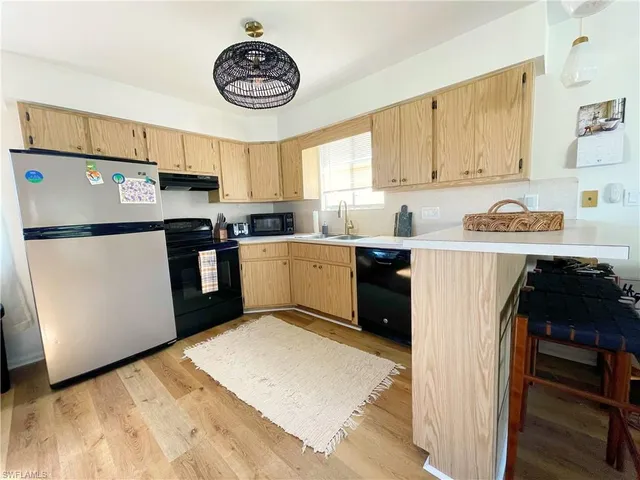 a kitchen with stainless steel appliances granite countertop a refrigerator a stove top oven a sink and dishwasher