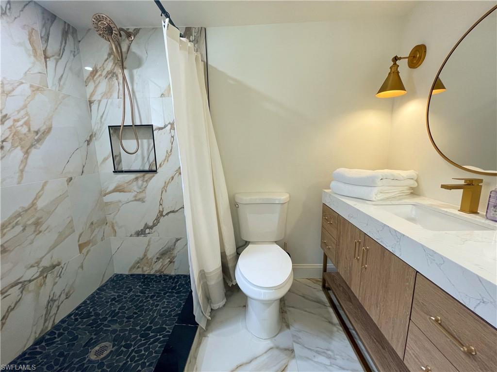 4811 Gary Road Bonita Springs, FL 34134 - Photo 23 of 35 Bathroom with light marble finish flooring, vanity, and a marble finish shower