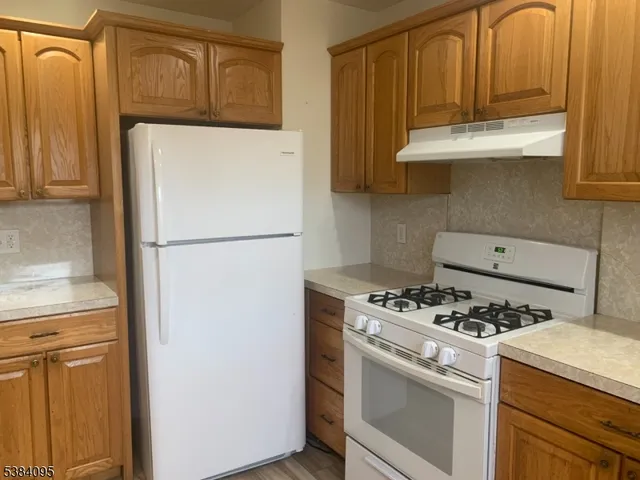 a kitchen with granite countertop cabinets and refrigerator