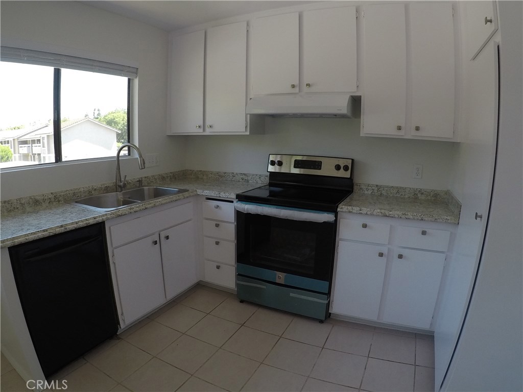 230 Springview Irvine, CA 92620 - Photo 8 of 30 a kitchen with granite countertop white cabinets and white appliances
