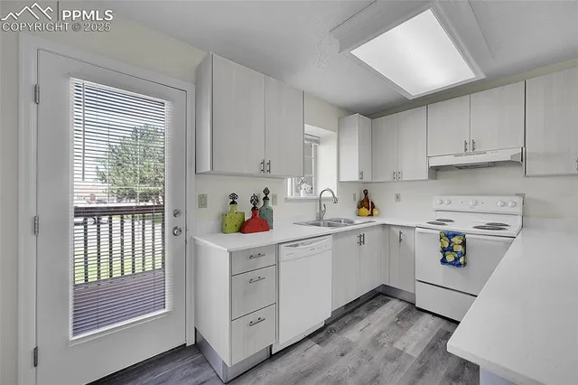 a kitchen with white cabinets and white appliances