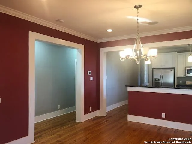 a view of a room with wooden floor and chandelier