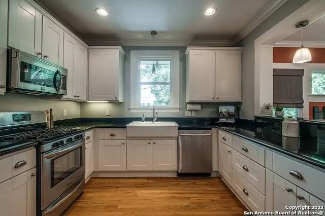 a kitchen with stainless steel appliances granite countertop a stove a sink and a microwave