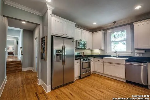 a kitchen with granite countertop a refrigerator and wooden cabinets