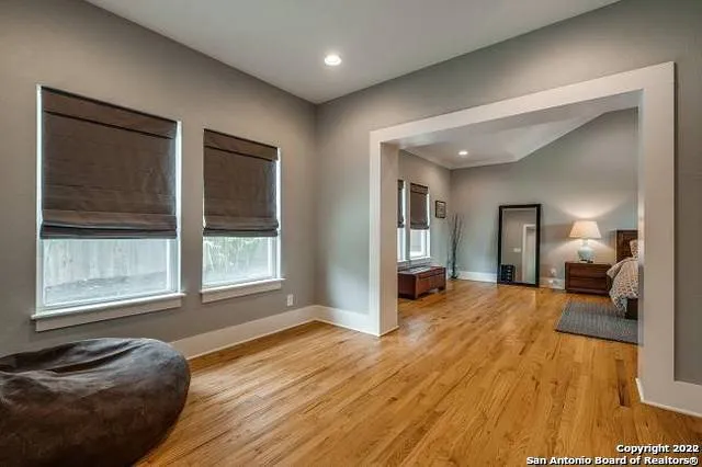a view of a livingroom with a flat screen tv wooden floor and bedroom