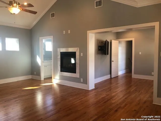 an empty room with wooden floor and staircase