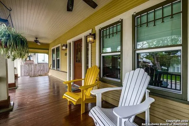 a view of a patio with table and chairs potted plants with wooden floor and floor to ceiling window
