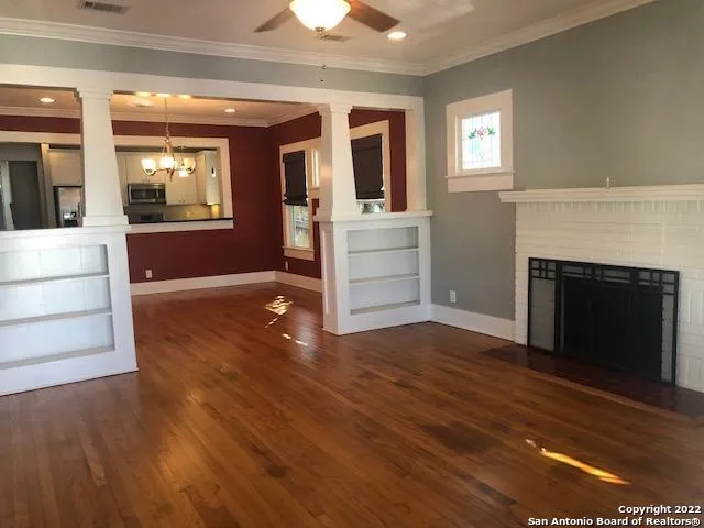 a view of a livingroom with wooden floor and a fireplace
