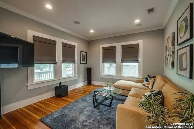 a living room with furniture windows and a flat screen tv