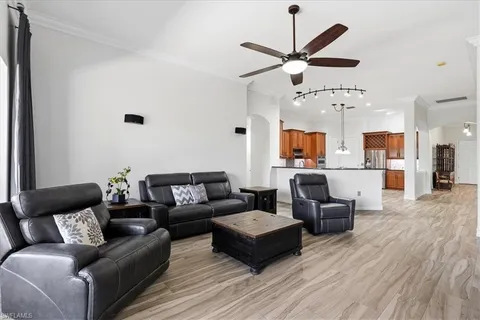 a living room with furniture kitchen view and a chandelier