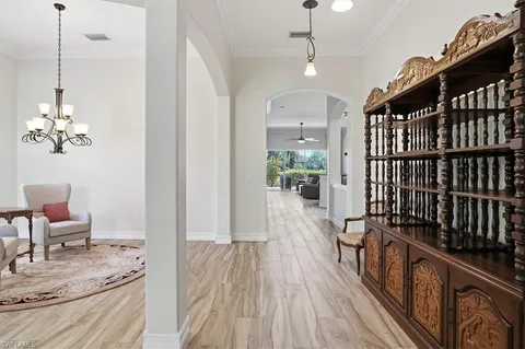 a view of a hallway with wooden floor and a chandelier
