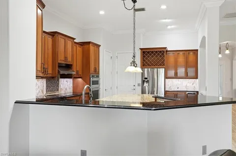 a kitchen with kitchen island granite countertop a stove a sink and a microwave
