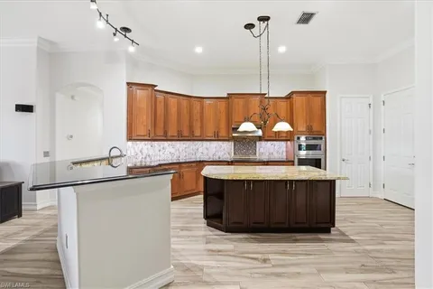 a kitchen with stainless steel appliances granite countertop a sink and a wooden floor