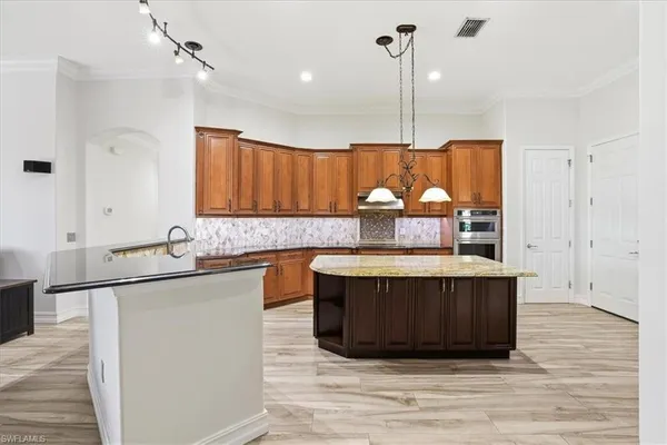 a kitchen with stainless steel appliances granite countertop a sink and a wooden floor