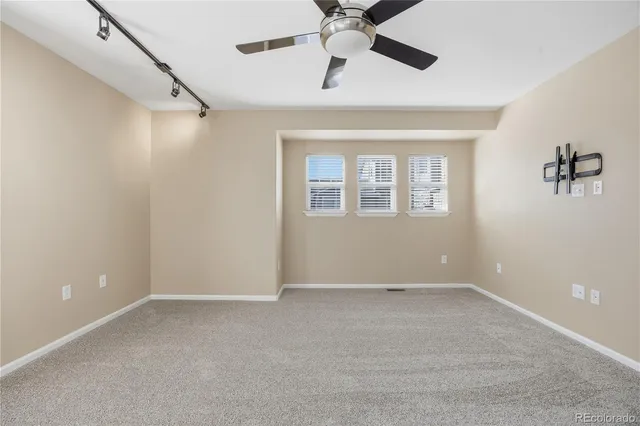 a view of an empty room with a ceiling fan